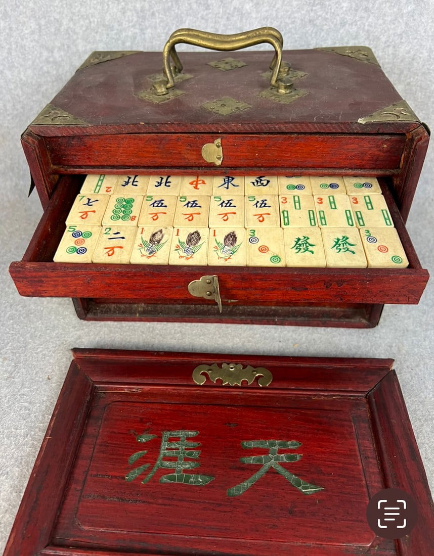 Vintage Mahjong Game In Wooden Case: Vintage Mahjong game tiles in their original brass bound wooden case. The game pieces are made of bone dovetailed to bamboo bases. Set appears to be in nice condition