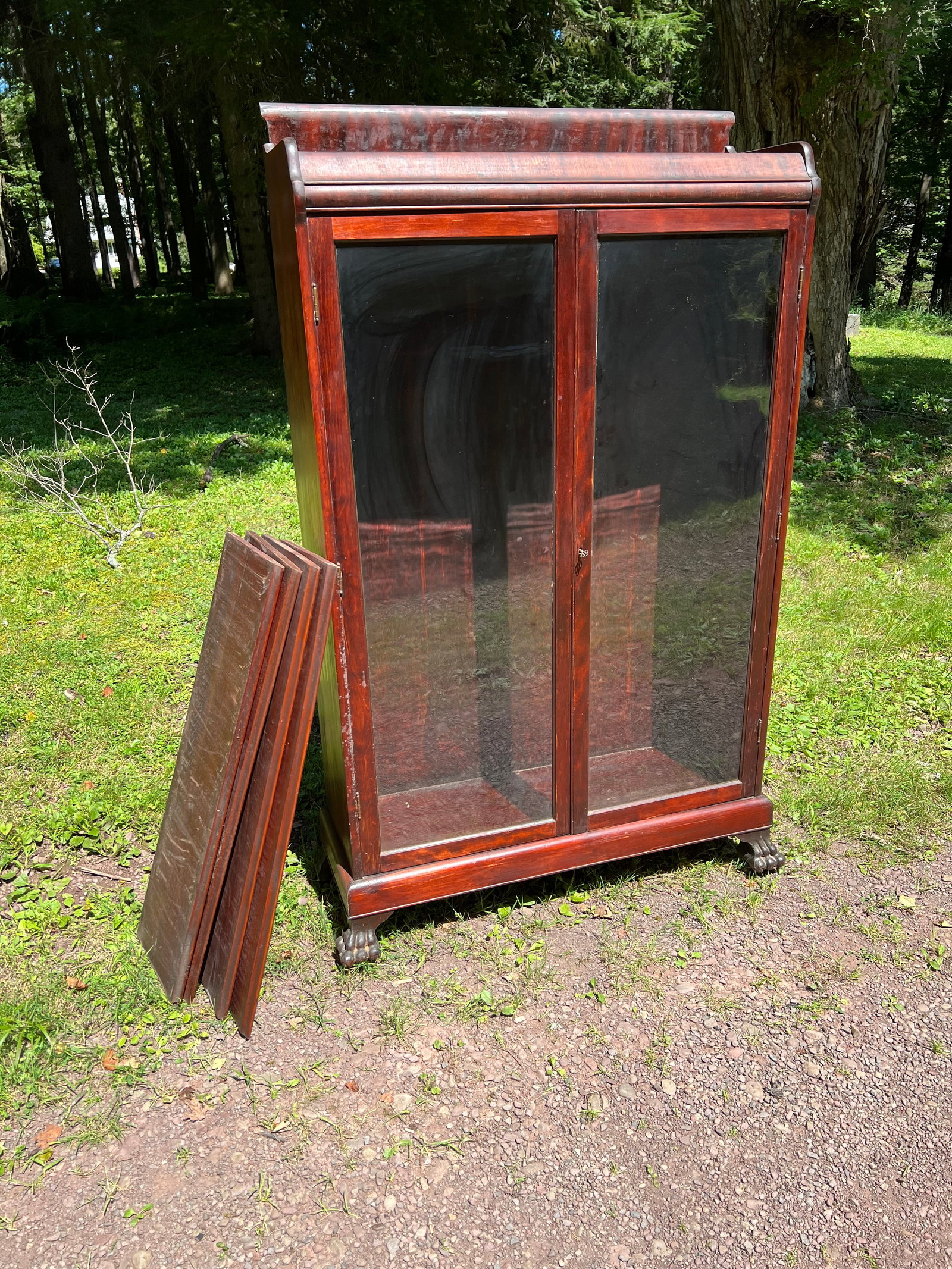 Mahogany Glass Front Bookcase: Mahogany Glass Front Bookcase with 4 shelves, front feet are figural paws. Measures 39.5" W x 13" D x 67" H. Good condition.