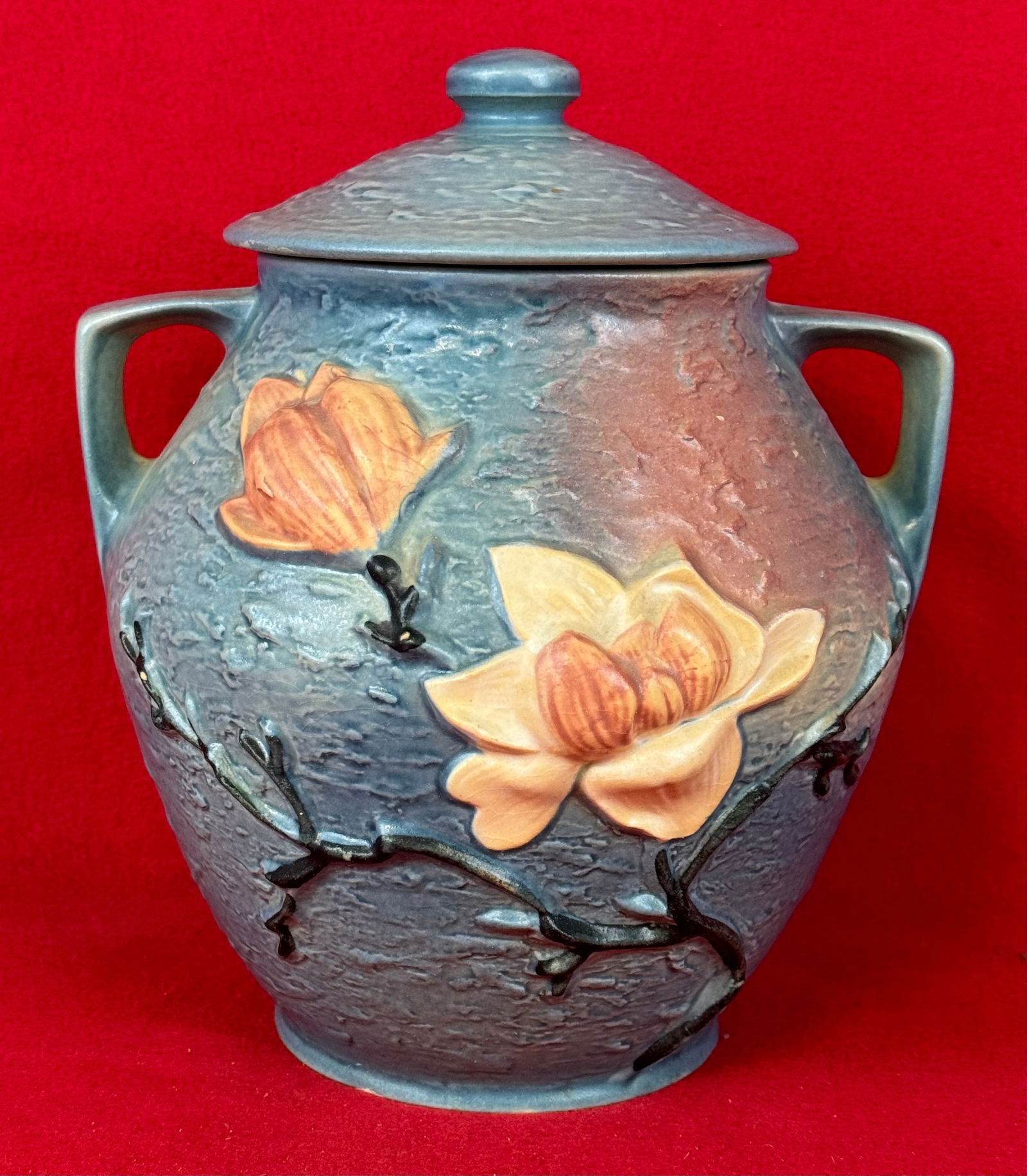 Roseville Blue Magnolia 2-8" Cookie Jar With Lid: Original Roseville 2-8" cookie jar with lid in the Magnolia pattern which dates to 1943. Jar is marked on underside of the base in relief Roseville / U.S.A. / 2-8" and is in the blue coloration. Cooki