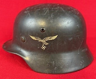 German Luftwaffe Model 35 Double Decal Helmet: World War Two German Luftwaffe Model 1935 double decal helmet with 85% of its dark blue-grey paint and with its original liner and having a chinstrap. Helmet retains about 90% of its Luftwaffe decal a