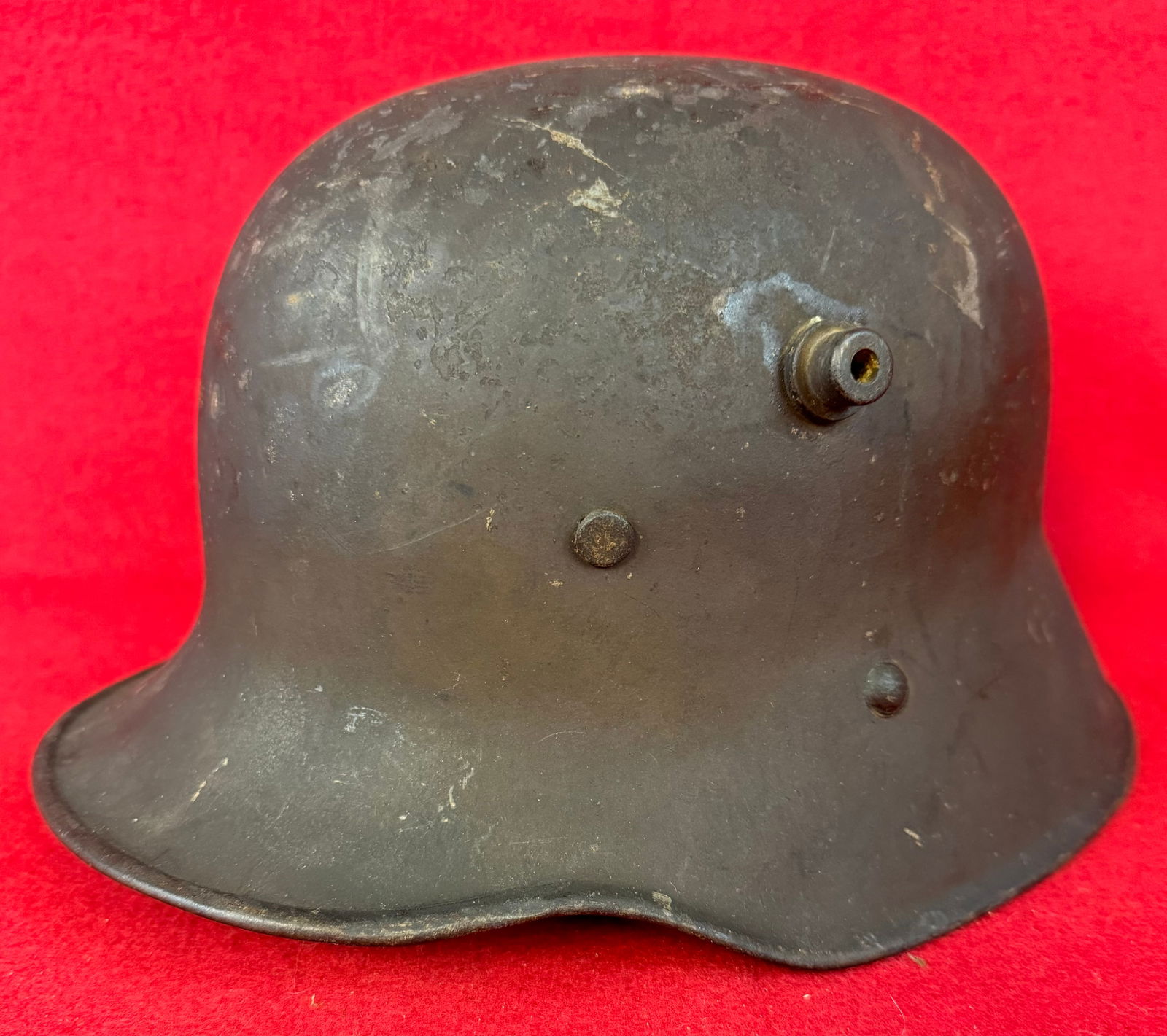 German / Austrian WW1 Model 1916 Helmet: German World War One model 1916 helmet with original dark olive brown paint. Helmet retains its original cloth chinstrap but appears to have a older replacement liner.