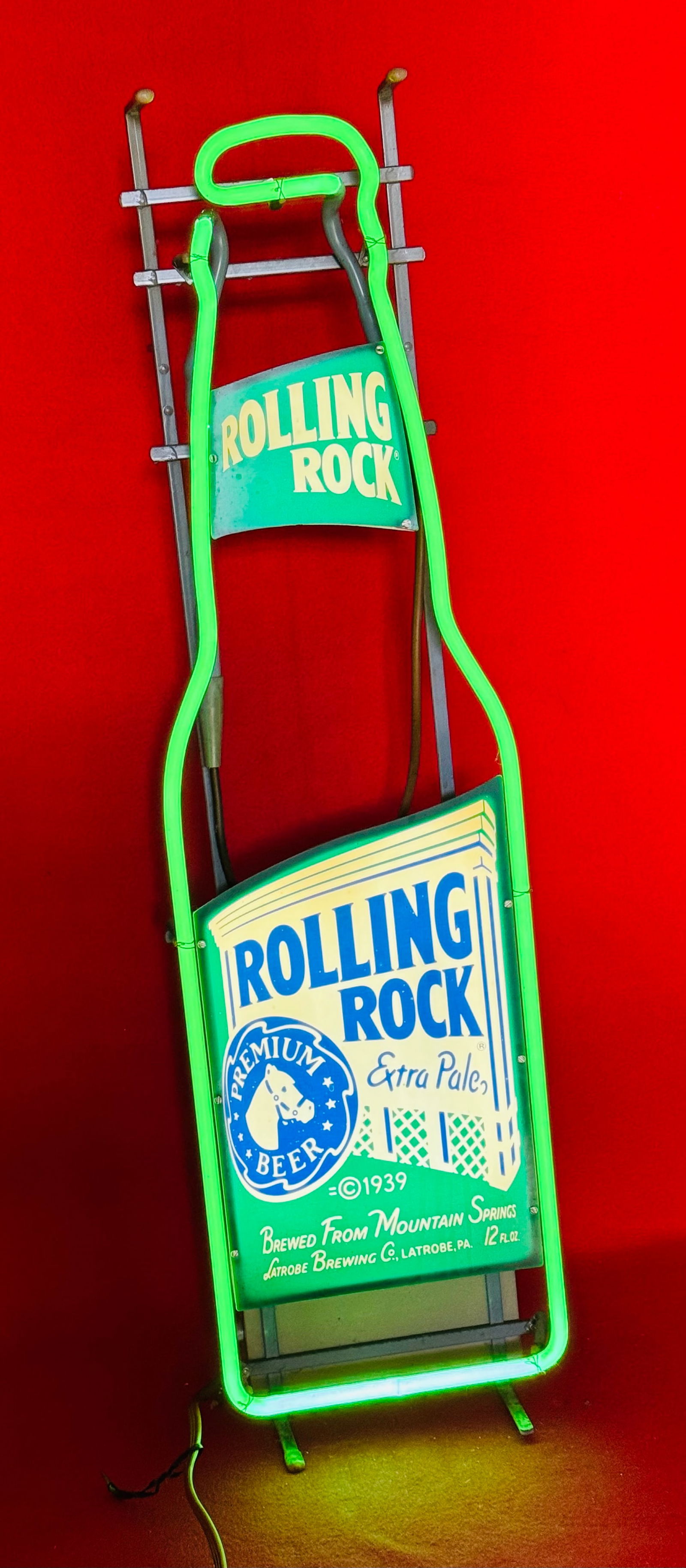 Vintage Rolling Rock Beer Neon Sign: Vintage Rolling Rock Beer neon sign with depiction of the bottle. Sign is in working condition and measures approximately 33 1/2" tall by 9" wide.