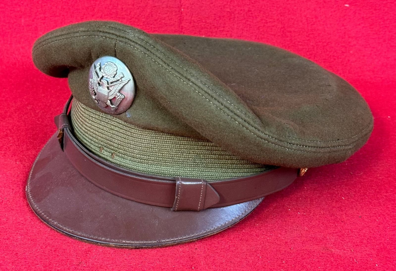 WW2 US Army Air Force Enlisted Visor Crusher Style Cap: World War Two Army Air Force enlisted visor crusher type cap with olive drab wool felt with brown leather visor and chinstrap. Cap was made by the Feldman Cap Company Denver Colorado and has a silvere