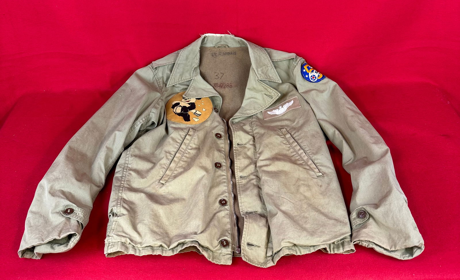 WW2 Named 5th Air Force Summer Flight Jacket W Leather Patch Etc.: World War Two summer flight jacket for the 5th Army Air Force with leather insignia on front and having hand painted Red Raiders logo with surrounding bombs depicted on back. Jacket has the name of it