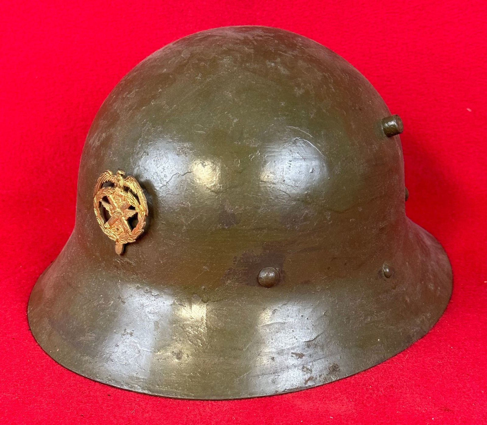 WW1 Helmet Apparently Recondition For Use In WW2: Helmet based upon German WW1 Helmet which may have been recondition for use in World War Two having been repainted and a badge mount with badge added. Country unkown for certain. Condition - old worki