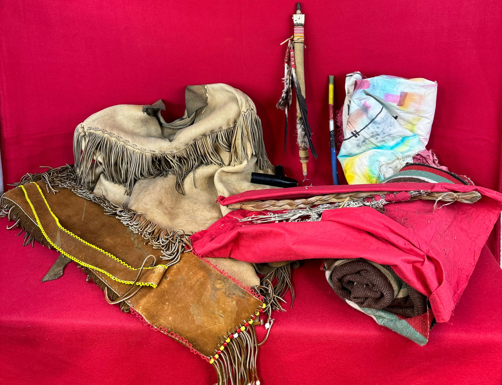 Lot 20th C Native American Related Items To Include Blanket and Black Stone Pipe Etc.: A lot of 20th century Native American related items to include a striped blanket, leather fringed shirt, colorfully dyed dress, carved blackstone pipe with carved wood, bead and feather decorated stem