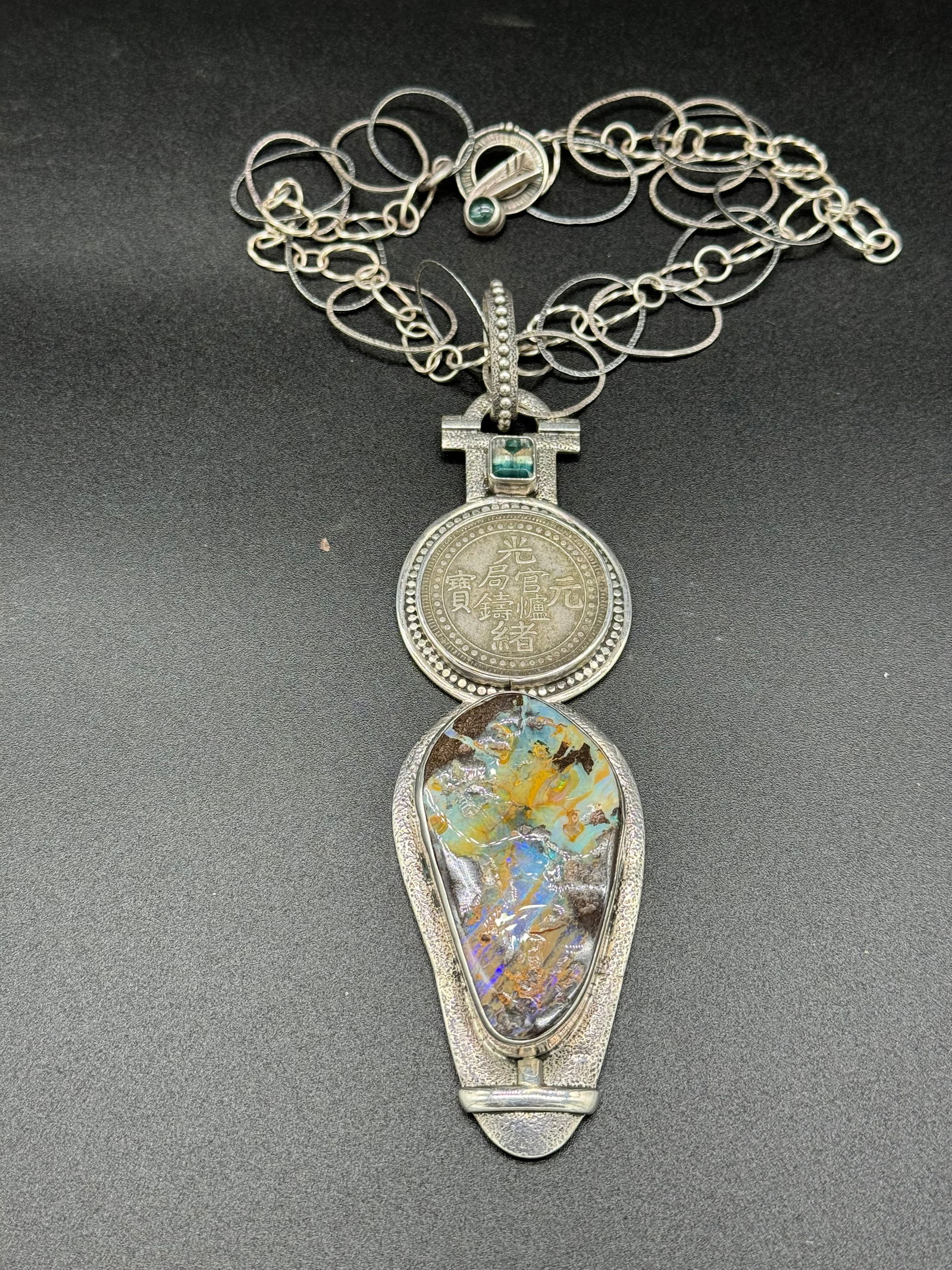 The Dreamer Ster Silver Opal/Tourmaline Pendant: Large natural opal and tourmaline encased in sterling silver pendant with sterling silver chain. Pendant is marked sterling on the reverse along with the name given to the piece by the artist "The Dre