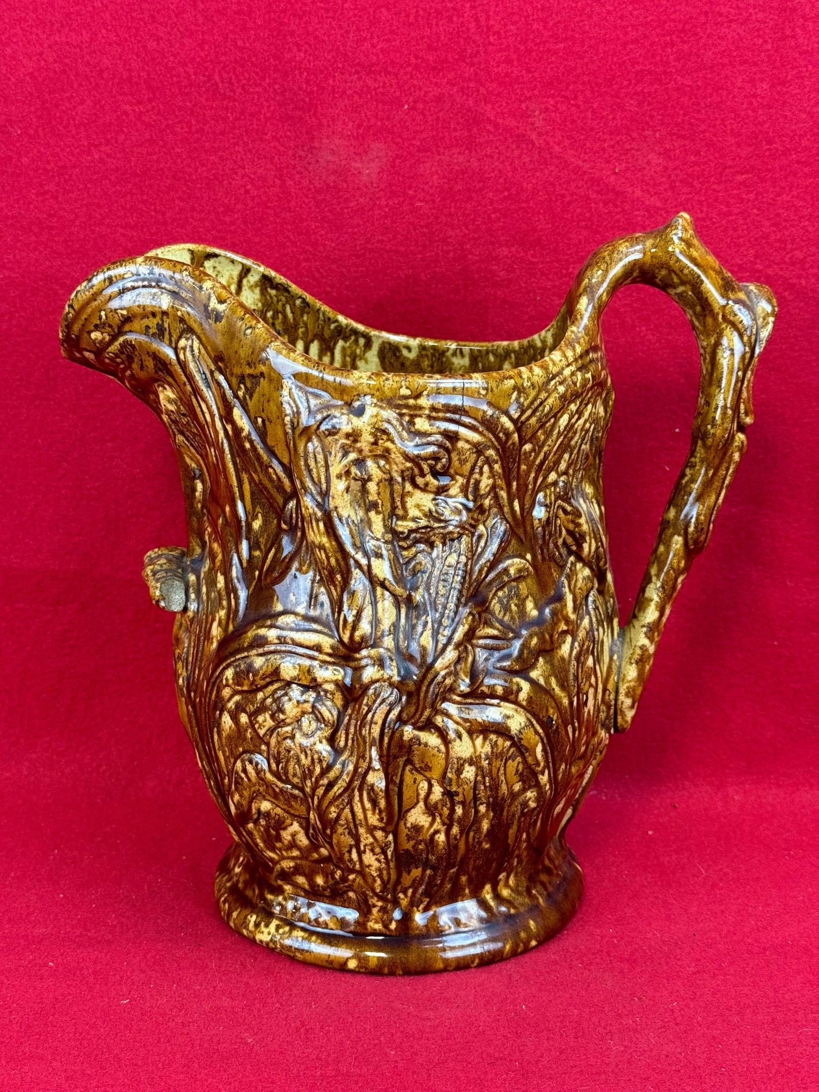 Lg Antique American Rockingham Pitcher: Large American rockingham glazed pottery pitcher with embossed carn stalk decoration. Pitcher has a small pour handle at front which is a unusual feature. Pitcher is quite large in size being 11" tall