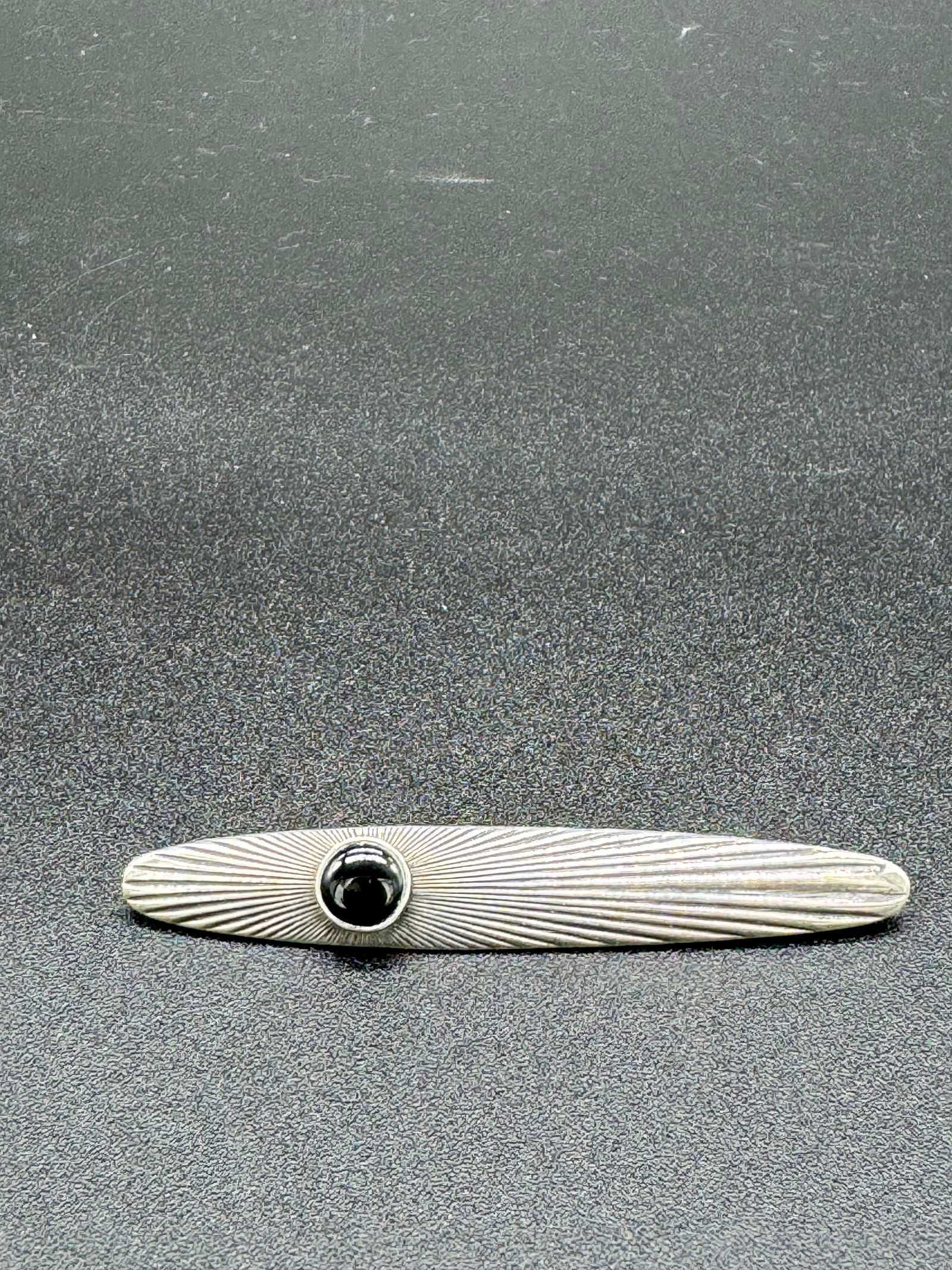 Sterling Modernist Bar Pin Set With Onyx: Sterling silver modernist styled bar pin which is set with a onyx. Pin measures approximately 3" long and weights .23ozt. Condition - excellent.