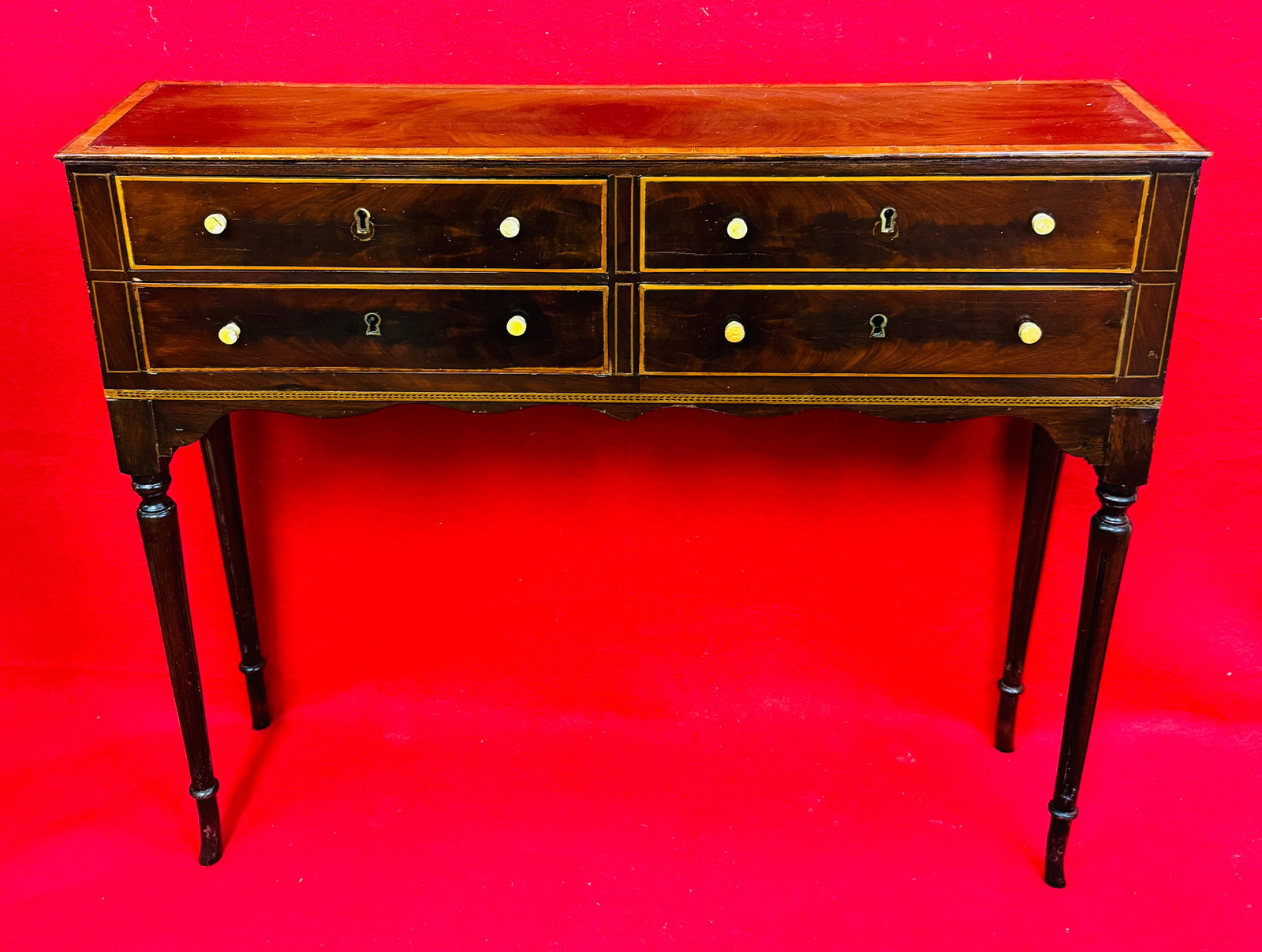 Antique Fine Diminutive 4 Draw Console Table: Antique Sheraton finely made diminutive four draw mahogany console table with string inlay and turned bone pulls. Table is up on four delicate reeded legs and each of the four draws has a keyhole and
