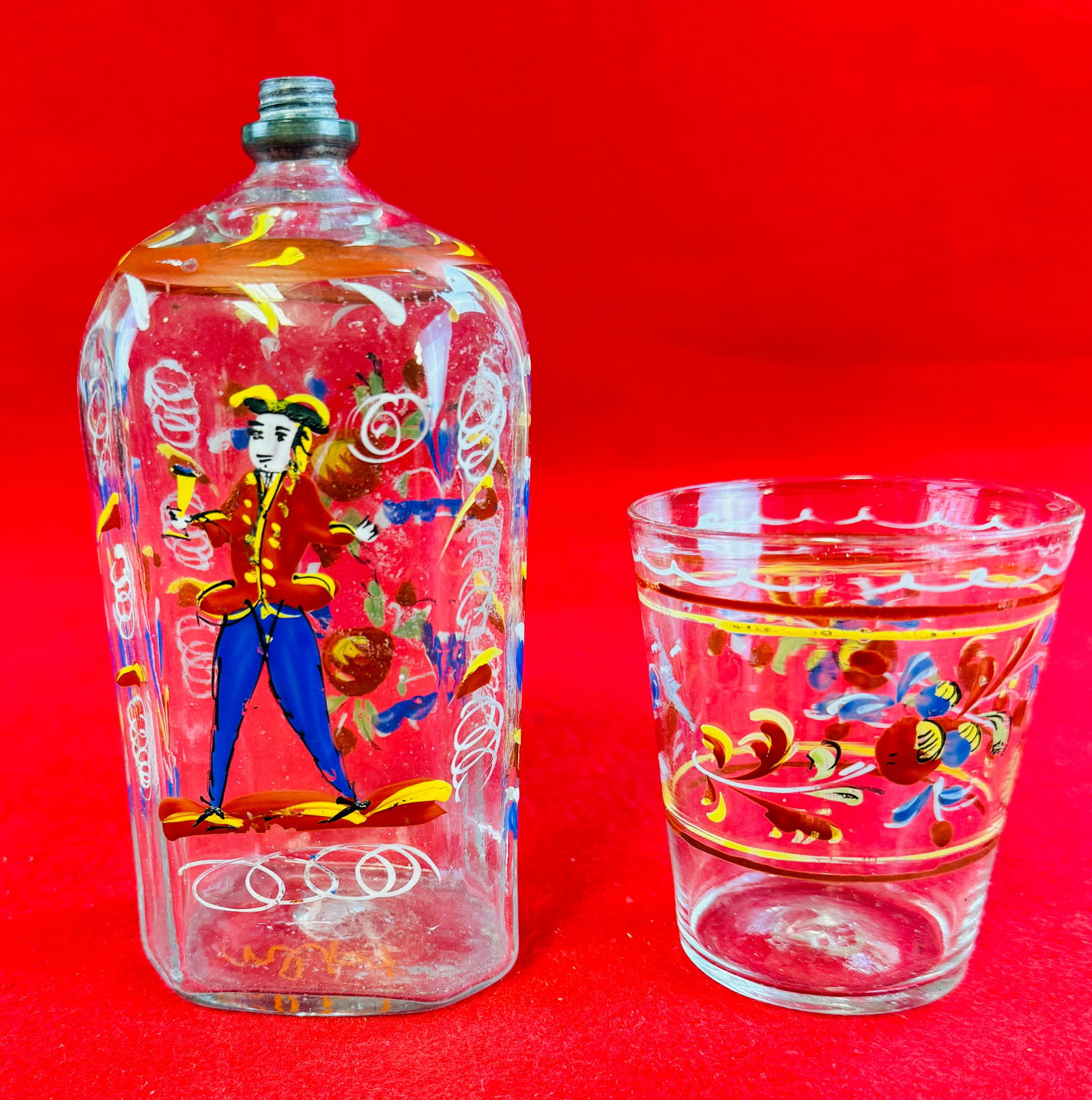 "Stiegel Type" Enamel Decorated Flask & Tumbler: Antique half post blown and decorated "Stiegel Type" bottle / flask of typical flattened octagonal form with hand painted polychrome enamel decorations in yellow, red, blue, white and black. Flask / b