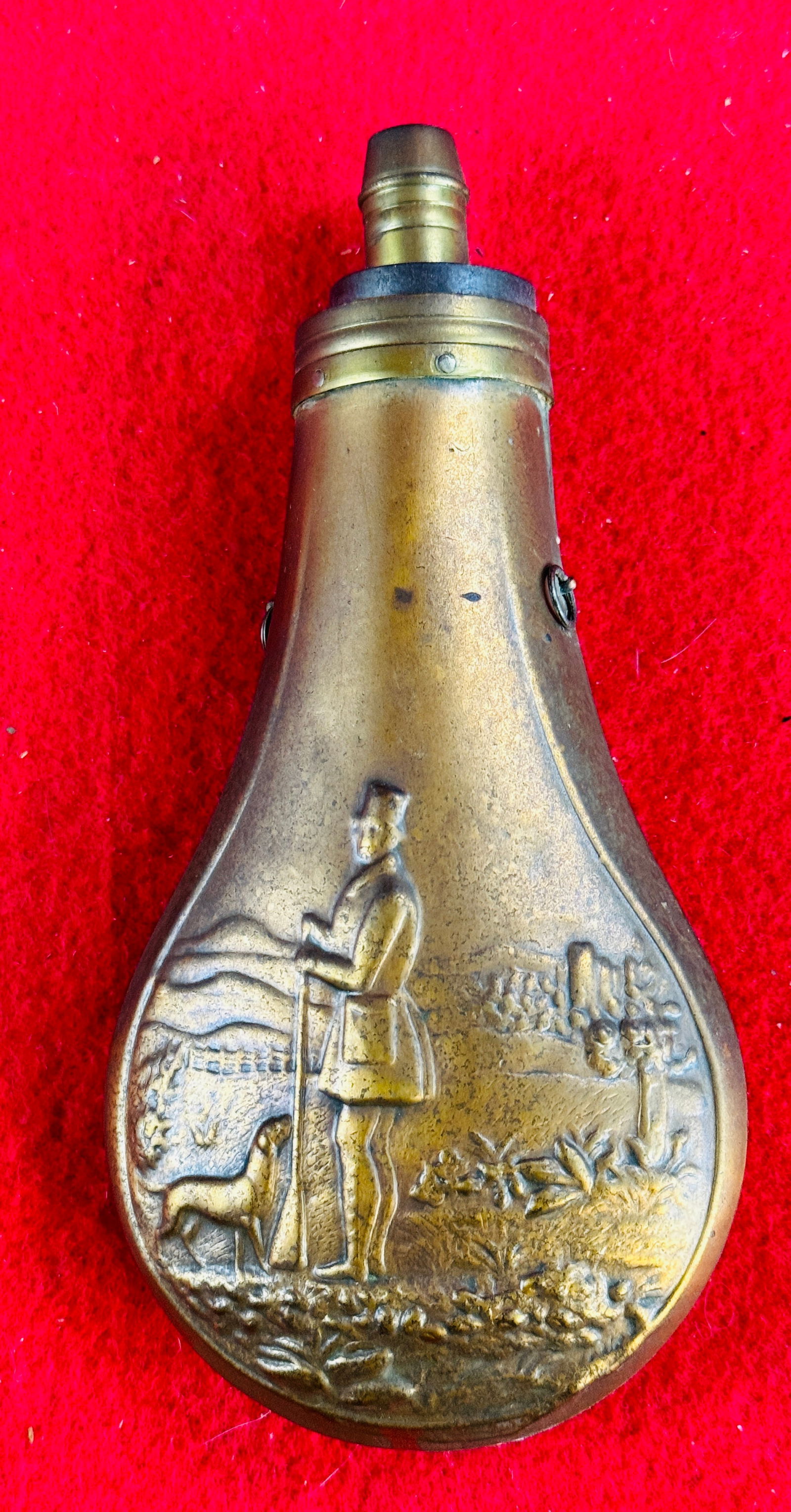 Antique Copper & Brass Powder Flask W Hunter etc: Antique copper and brass powder flask which features a embossed depiction of a standing hunter holding his gun and having a hunting dog standing at his feet. The powder flask has a scratched in name a