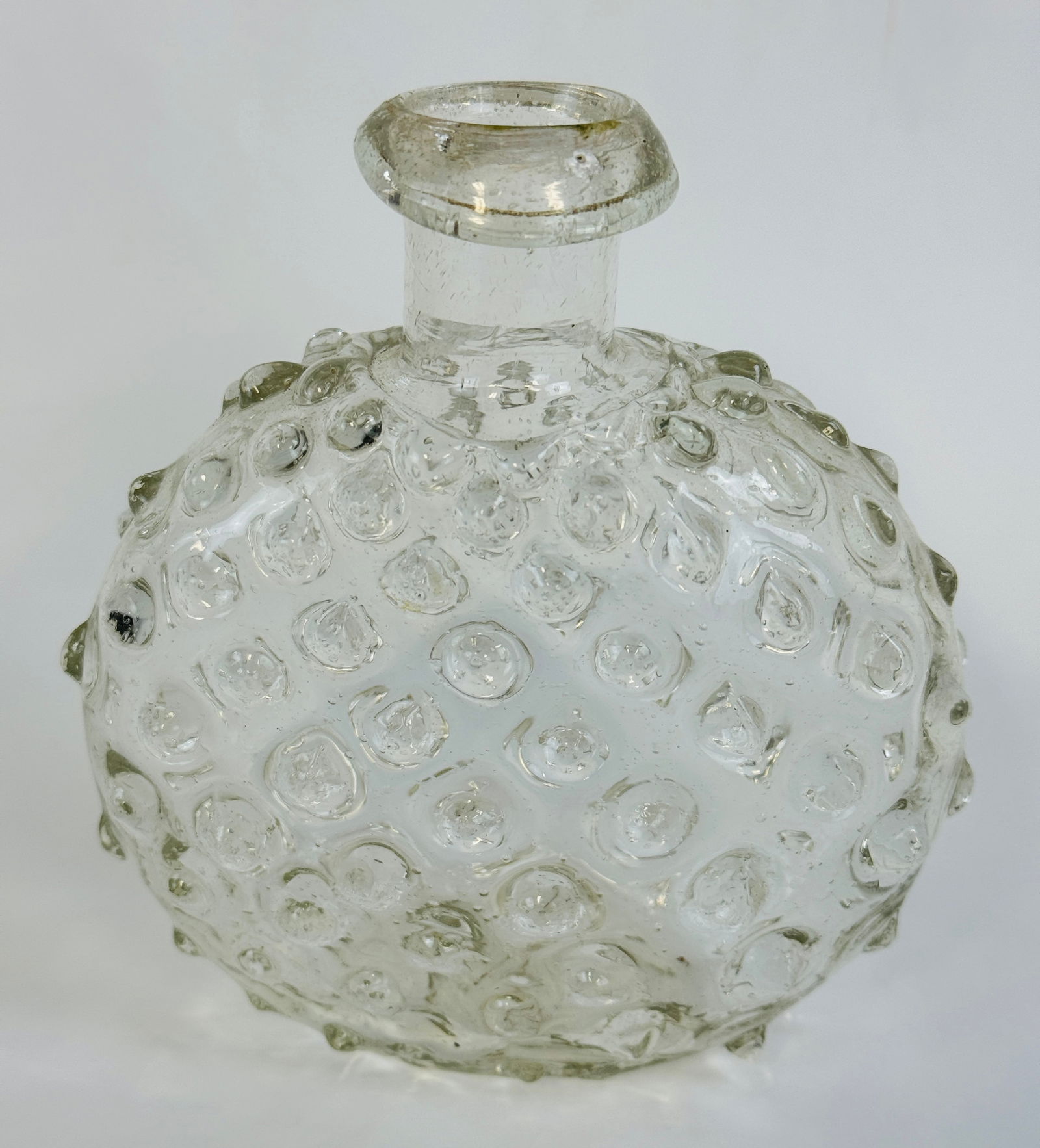 KU-26 Early Pontil Marked Hobnail Poison Flask: 4 7/8" half post mold clear poison flask with a rolled lip and having hobnail decoration over its body. Bottle has a pontil marked base and is identified in Kuhn as KU-26. A very rare, very early pois
