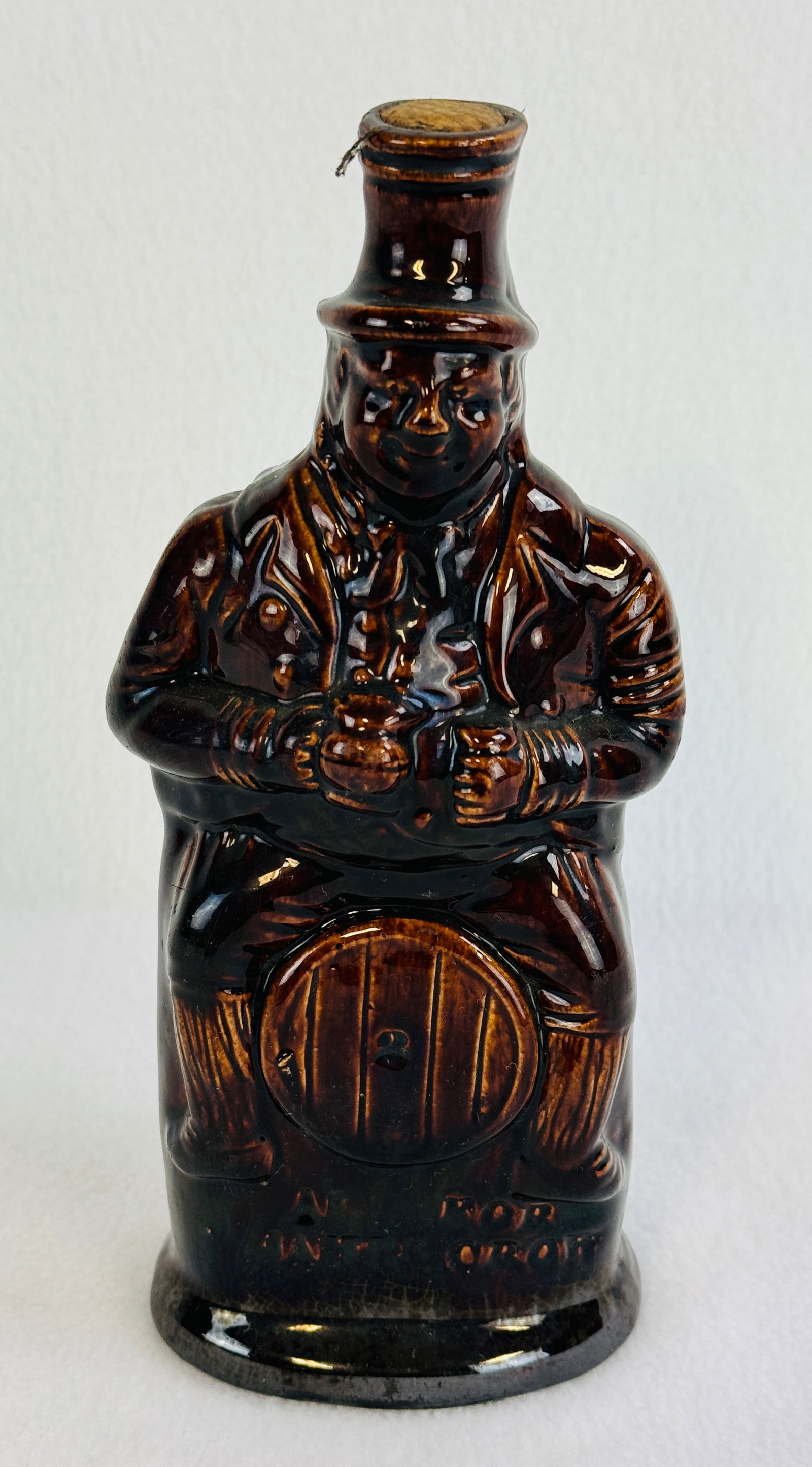 Ask For James Crow Figural Rockingham Glazed Flask: 9 1/8" Rockingham figural flask in the form of a man on a barrel which is impressed below the barrel ASK FOR / JAMES CROW. Condition - excellent.