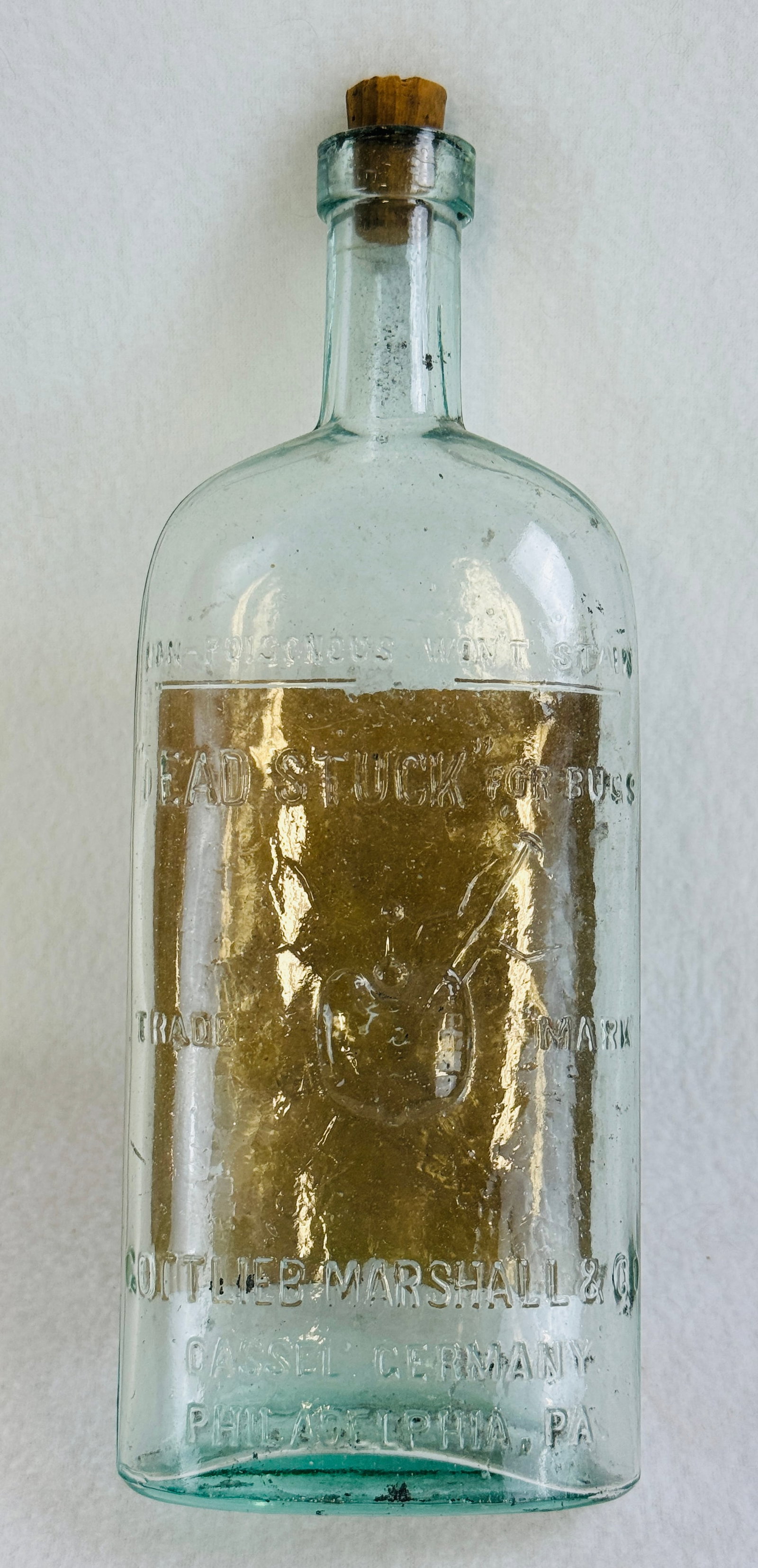 Dead Stuck For Bugs Bottle With Original Label: 9" aquamarine blown in mold with tooled top bottle for Dead Stuck For Bugs put out by Gottlieb Marshall & Co Cassel Germany and Philadelphia Pa complete with 95% of its original paper label on reverse