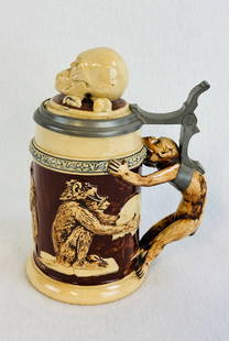 German Monkey Stein W Skull & Crossbones Inlaid Lid: German made pottery stein with depictions of a monkey reading books while another contemplates a human skull etc on its sides with a figural monkey handle and which has a inlaid lid the top of which i