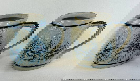 Lot 2 Blue & White Molded Stoneware Barrel Form Mugs: Lot of two approximately 5" tall blue and white molded stoneware barrel form mugs one of which has impressed advertising at its base for Richard Briggs Co Boston. Both mugs have a white kaolin coated