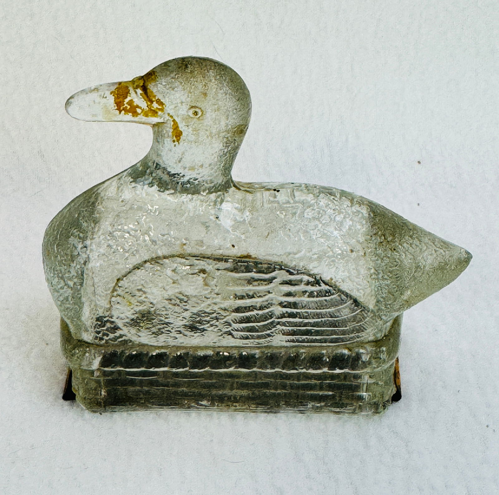 Candy Container - Duck In Basket: Clear glass candy container in the form of a duck seated on a basket complete with its original tin closure. Condition - free of chips or cracks. Note: Most items in this auction we will offer our in-