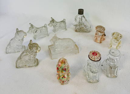Lot 11  Candy Containers - Dogs: Lot of eleven clear glass and one plastic figural candy containers in the form of dogs. Condition - is as shown. Note: Most items in this auction we will offer our in-house shipping as opposed to usin