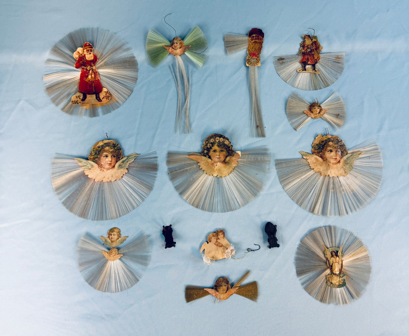 Lot 11 Scrap Christmas Tree Decorations: Lot of eleven antique cotton spun scrap Christmas decorations which include lithographed depictions of Angels, Santas etc. Condition - wear as shown.