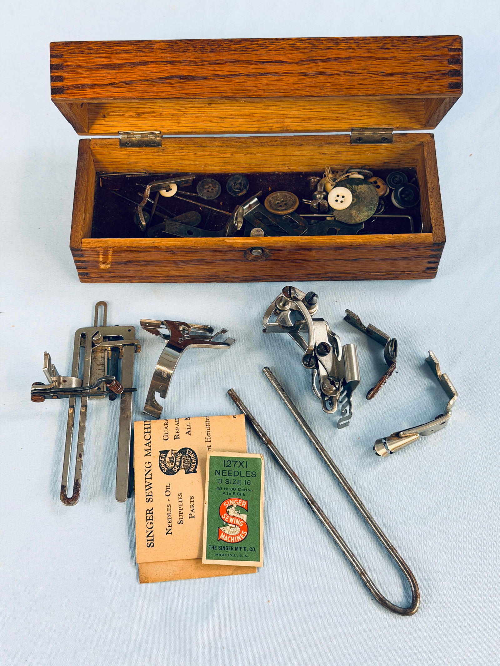 Wheeler & Wilson Advertising Box & Sewing Accessories: Antique pressed oak advertising box for the Wheeler & Wilson company sewing machines. The box is filled with various sewing machine accessories. Box measures approximately 8 1/2" long by 2 3/4" tall b