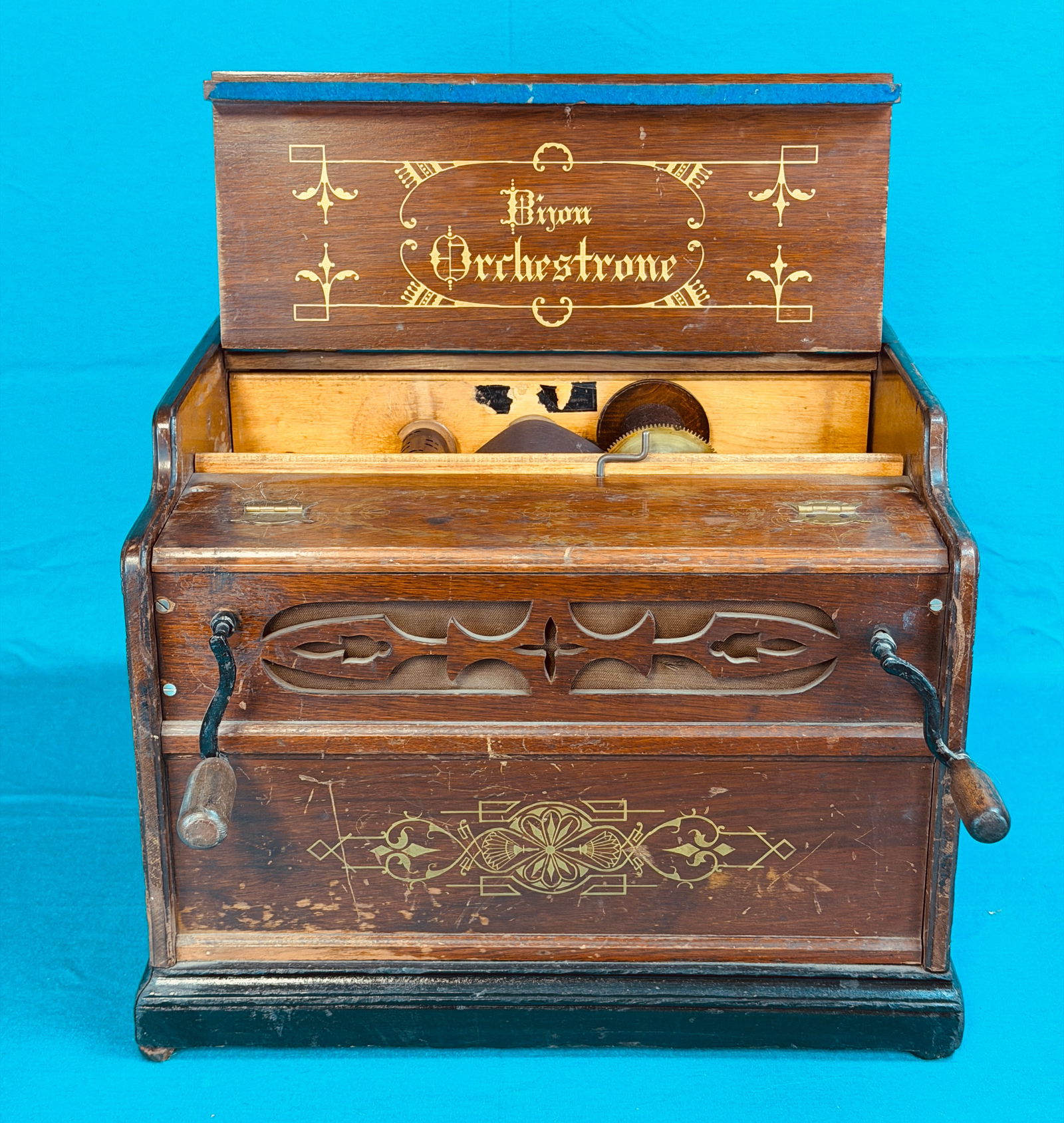 Antique Walnut Cased Bijou Orchestrone Organette: Antique walnut cased Bijou Orchestrone hand cranked paper roll organette which comes with one roll. Organette measures approximately 13" tall by 16" wide by 13" deep. Organette plays but only seemingl