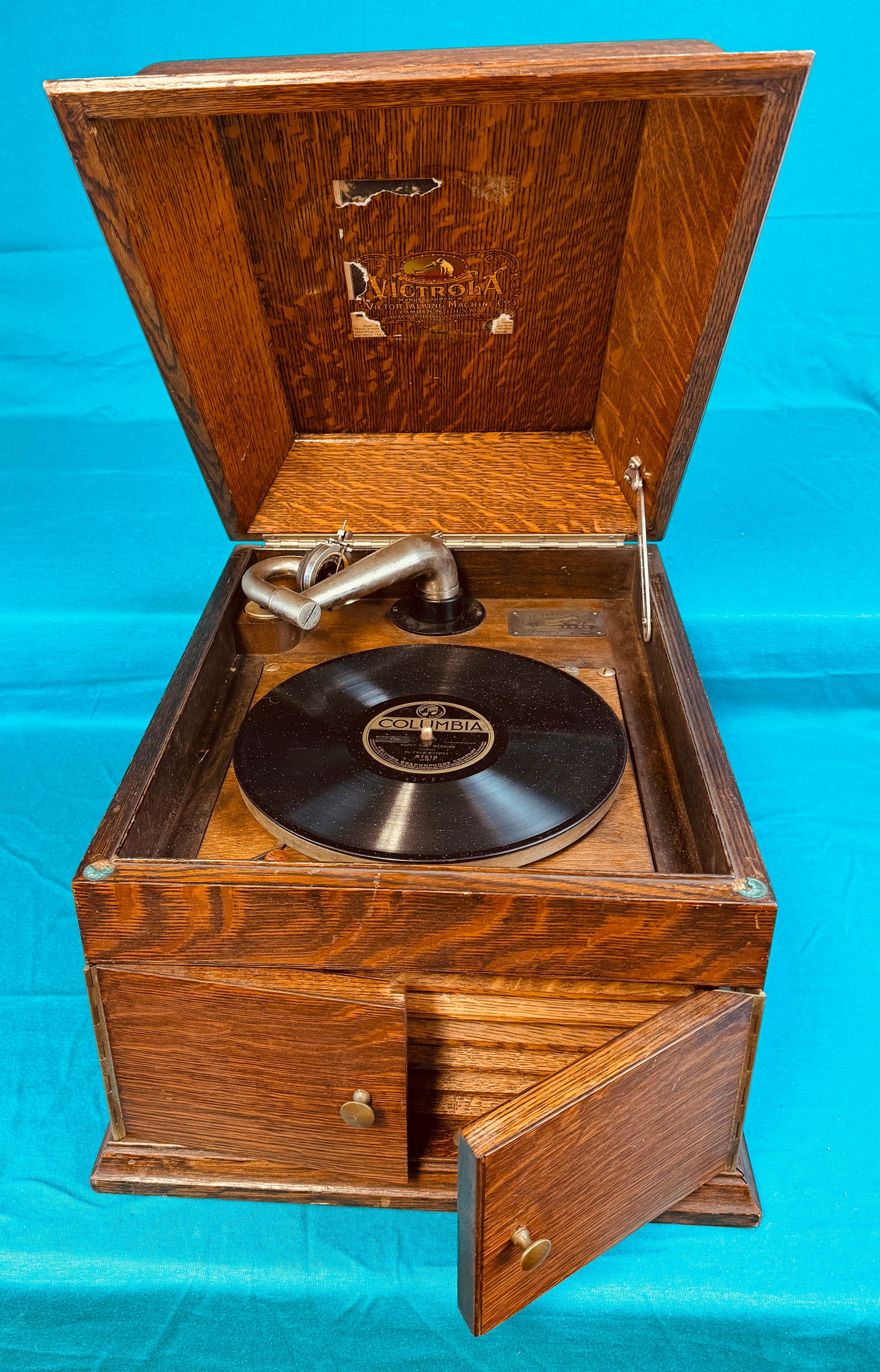 Oak Cased Tabletop Victor Victrola: Oak cased Victor Victrola disc record player which measures approximately 13" tall by 15" wide by 19" deep. Victrola has lost its four tiny wooden disc feet beneath case and has a broken crank handle