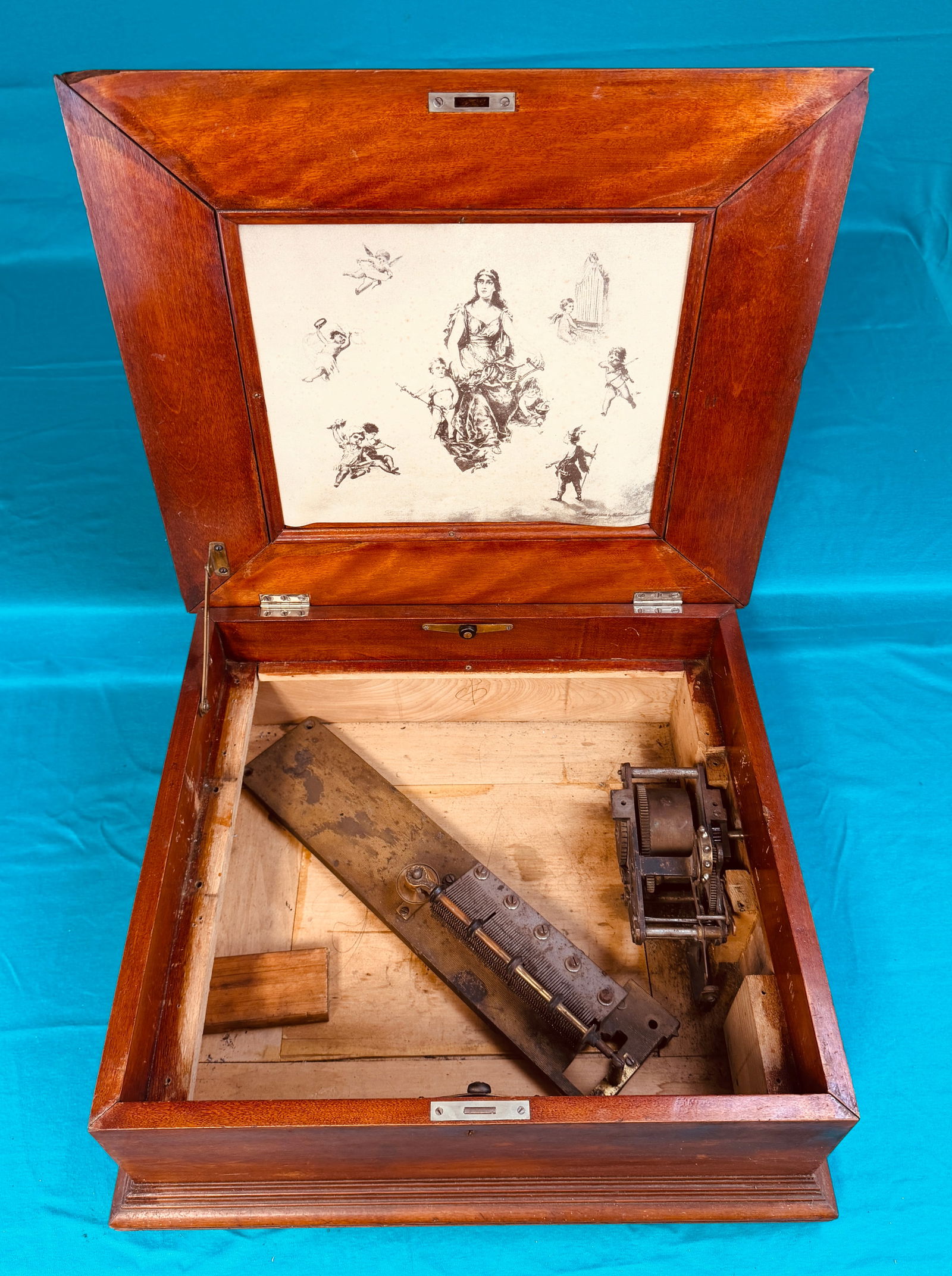 Antique Disc Music Box Case And Parts: Antique disc playing music box case along with a drive motor and a comb (lacks one tooth). Case appears to be of cherry and measures approximately 21" wide by 19" deep by 8" tall. Condition - as shown