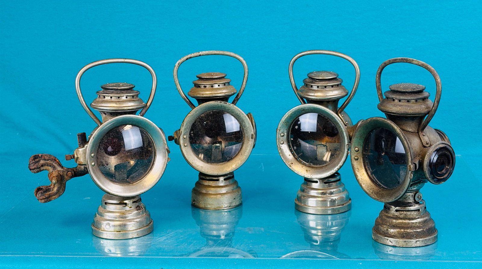 Lot 4 The Neverout Lamps: Lot of four The Neverout buggy, carriage or early automobile lamps made by the Rose Manufacturing Company Philadelphia Pa. Lamps are made of brass with a nickel plating and one has the original bracke