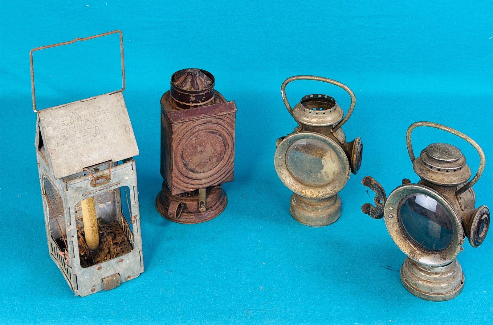 Lot 4 Antique Lamps / Lanterns: Lot of four antique lamps / lanterns which include two The Neverouts made by the Rose Manufacturing Company, a dark room lantern and a Stonebridge folding lantern. Condition - is as shown with wear et