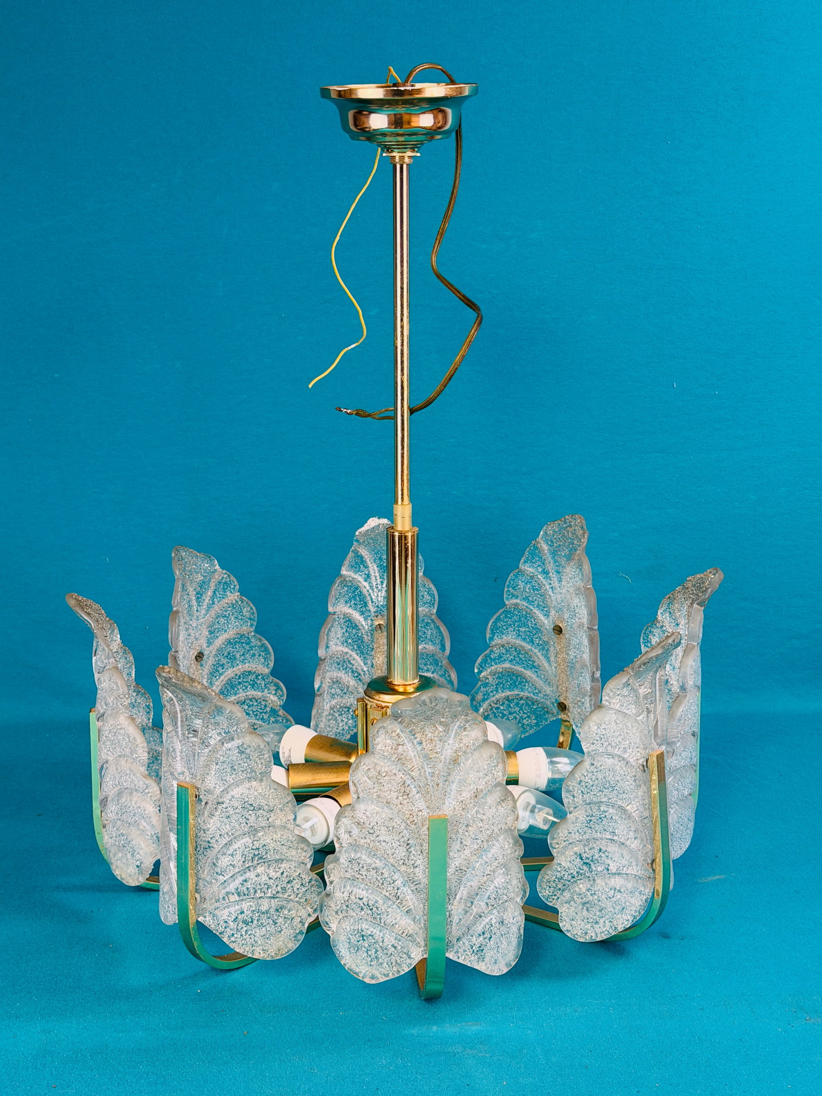 Mid Century Murao Glass Chandelier: Mid century modern Murano glass chandelier with eight heavy clear molded leaf form light covers with applied glass sand on their interior. Chandelier measures approximately 20" in diameter and is 24" 