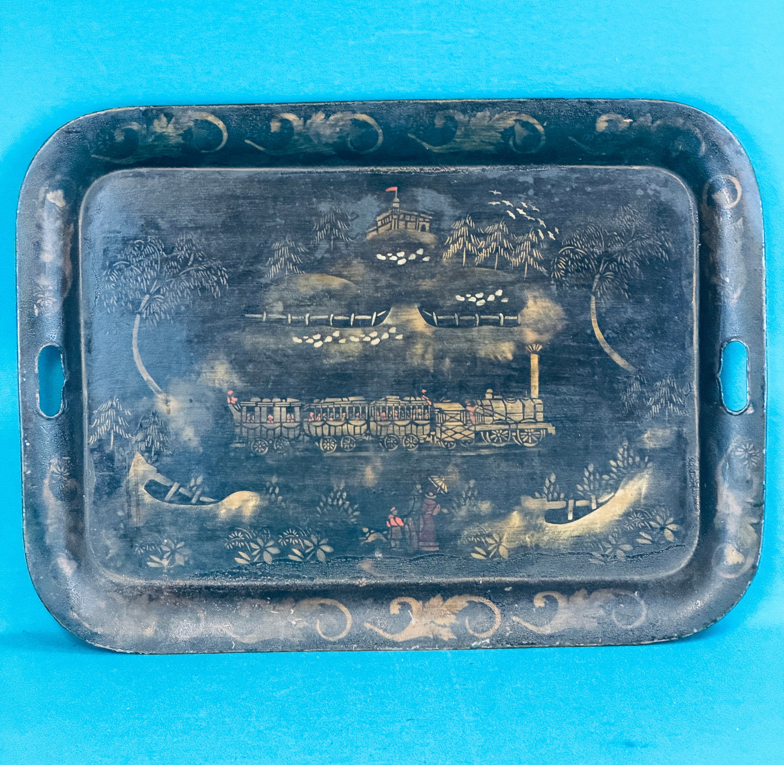 19th C Toleware Tray w Train Etc: Antique 19th century heavy toleware tray with a stencil scene featuring a early train with cars in a landscape setting. Tray measures approximately 24" by 17 1/2". Condition - fine with some minor