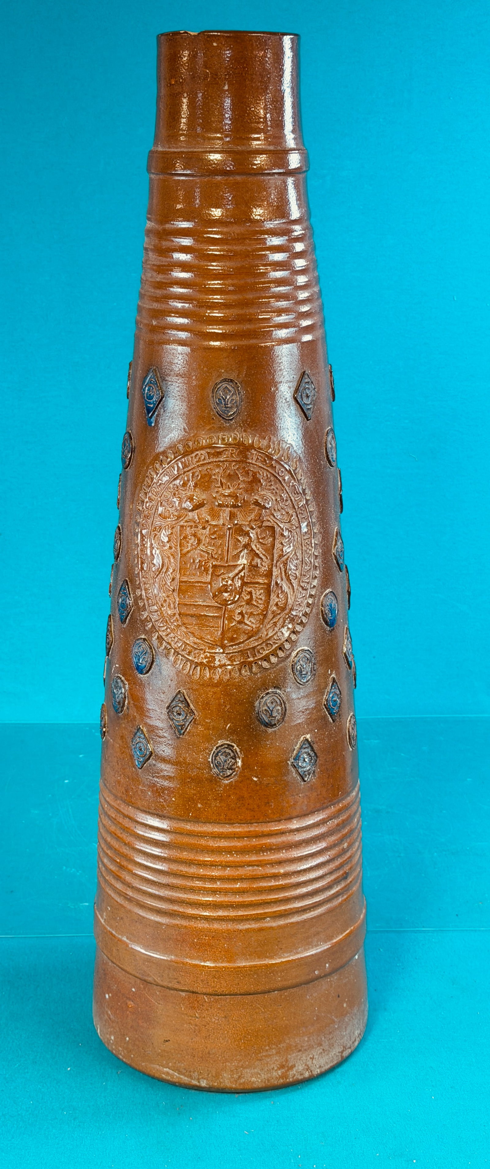 Large 33 1/4" Raeren Pottery Vessel: Large 33 1/4" tall piece of Raeren pottery with a iron oxide glaze and having applied seals highlighted with cobalt. Piece of stoneware which was most likely made in the present area of Belgium has a 