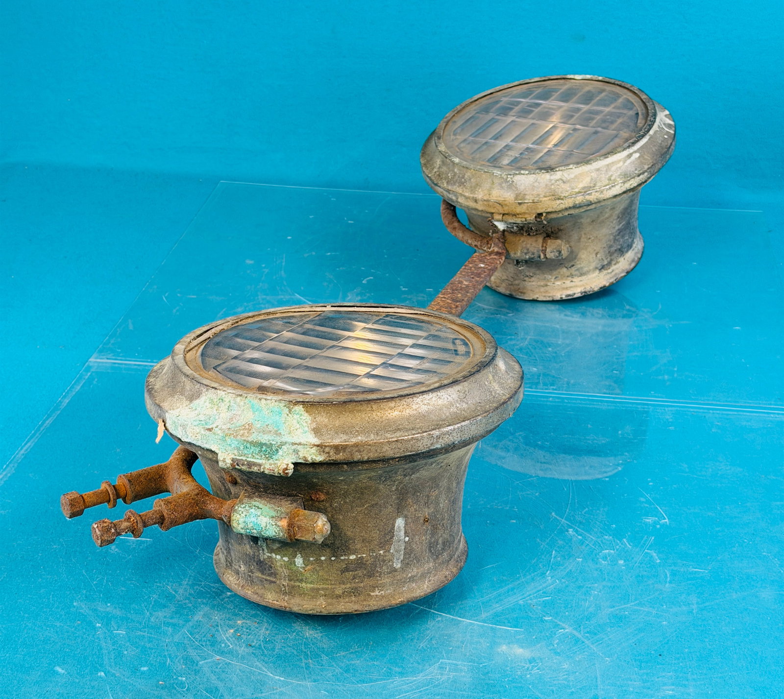 Model T Headlights w Mounting Bracket: 1920's Model T headlight set with its original iron mounting bracket. Lamps have Warner-Patterson lenses one of which is damaged. The lamps are of brass with nickel plated brass front bezels. Conditio