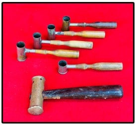 Lot Antique Powder Measures Etc: Lot of five antique gun powder and shot measures along with a brass headed small hammer possibly used by a gunsmith. Condition - is as shown. Two Feathers will offer our in-house shipping on this lot.