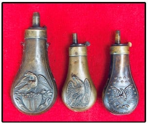 Lot 3 Eagle Decorated Powder Flasks 2 Pistol Size: Lot of three antique copper / brass powder flasks each of which is decorated with a embossed American Eagle design two of which are small pistol size while the third is a bit larger at 5 3/4" in total