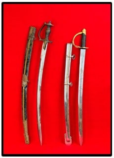 Lot 2 Indian Swords Including Traditional Rajput: Lot two Indian made swords / sabers which includes a traditional curved blade Rajput with stamped tin mounted velvet covered scabbard. The hilt is made of solid brass which is ornately engraved. The b