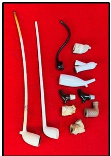 Lot Antique Smoking Pipes Including Excavated: Lot of antique smoking pipes which include two clay specimens with complete or near complete stems the longest of which measures approximately 16" in length and retains its original paper label. There