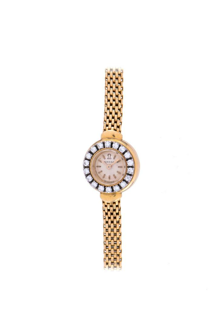 OMEGA LADIES WRISTWATCH: Case: yellow gold 750/1000 case, 18 brilliant-cut diamonds on bezel; Dial: white dial, signed "Omega"; Movement: redgold plated manual winding movement, Cal: Omega 440; D= 16 mm, ca. 1960
