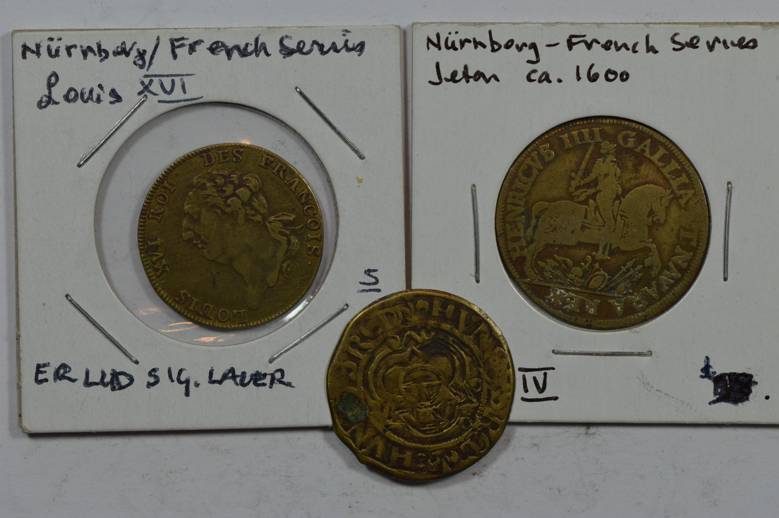 A Trio of Brass Jetons: A Trio of Brass Jetons (circa 1500-late 1700's). This lot includes examples depicting a galloping Henri IV of France, a bust of Louis XVI of France, and a German Imperial orb. A total of 3 pieces, all