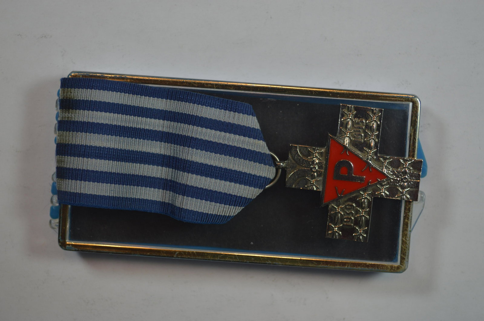 Poland, Auschwitz Cross (Silver?, circa 1985-1995).: Poland, Auschwitz Cross (Silver?, circa 1985-1995). This medal is still intact with its ribbon and plastic box of issue (the reverse of the box with a magic marker notation). The reverse legend roughl