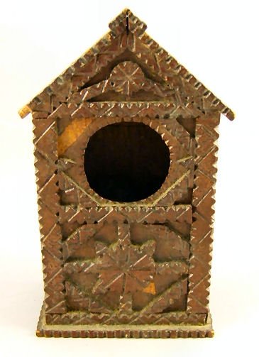 Folk art / tramp art chip carved pocket watch hold: Folk art / tramp art chip carved pocket watch holder, 6.5" high, original old finish, two missing pieces, chip on edge of "roof", small split on base