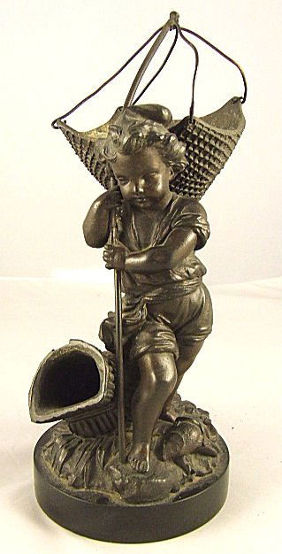 Spelter figurine of boy with fishing net, fish and: Spelter figurine of boy with fishing net, fish and fish trap at feet, mounted on slate base, measures 11" high.