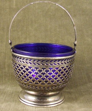 Watson sterling silver sugar basket with cobalt in: Watson sterling silver sugar basket with cobalt insert, no damage to sterling or glass liner, 3 3/8" wide, 5.5" high to top of handle. No monograms, 2.27 troy oz. silver weight.