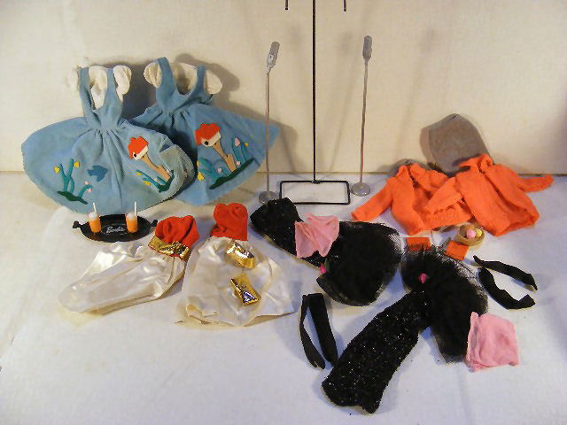 1950's - 60's Barbie clothes. 8 outfits, 2 black d: 1950's - 60's Barbie clothes. 8 outfits, 2 black dresses w/ microphones, 2 white dresses w/ red tops, 2 blue dresses w/ bird houses, 2 skirts w/ orange tops. 1 stand.