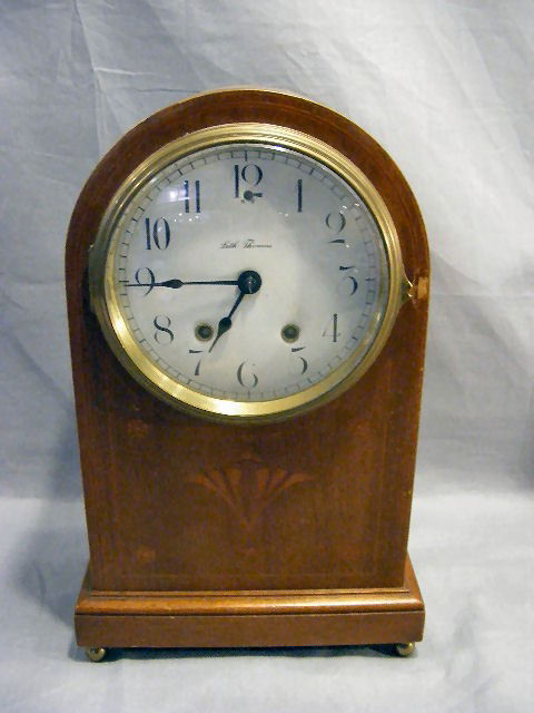 Seth Thomas cottage clock, enameled face, inlay on: Seth Thomas cottage clock, enameled face, inlay on front of case, brass feet. Some scratches in case. Brass works. 14.5" tall. Has pendulum.
