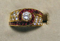 Van Cleef & Arpels 18K gold ruby and diamond ring: Van Cleef & Arpels 18K gold ruby and diamond ring, size 6.25, center diamond approx. 40 pts, 6 diamonds on each side of center stone, 22 rubies. No damaged stones. 7.9 grams total weight. Marked insid