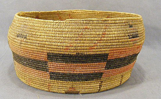 Native American weaved basket w/ red & brown deco: Native American weaved basket w/ red & brown decoration. Some damage and fading to color. 12.25" diameter x 5.25" tall.