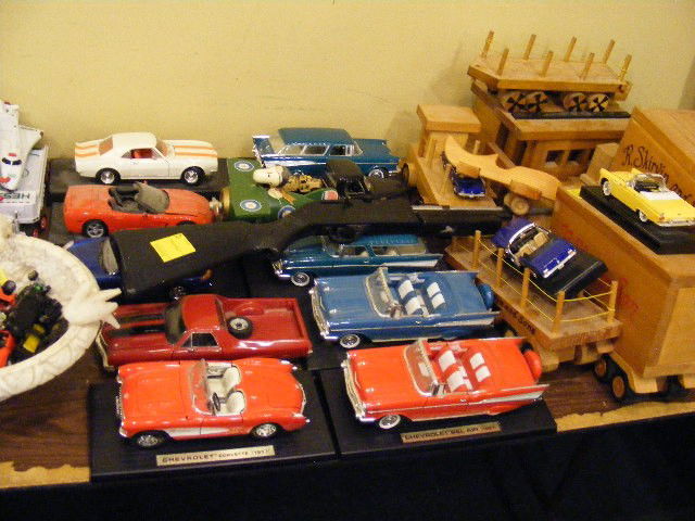 Table lot, die-cast models, wooden train & trucks: Table lot, die-cast models, wooden train & trucks, bb gun, Hess trucks, Hot Wheels, alabaster bird bath, etc.