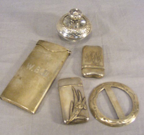 Lot of sterling silver including Carlos Diaz buck: Lot of sterling silver including Carlos Diaz buckle, large match holder with broken hinge, dented match safe, match safe with embossed floral decoration, and lighter with sterling overlay. Weight excl